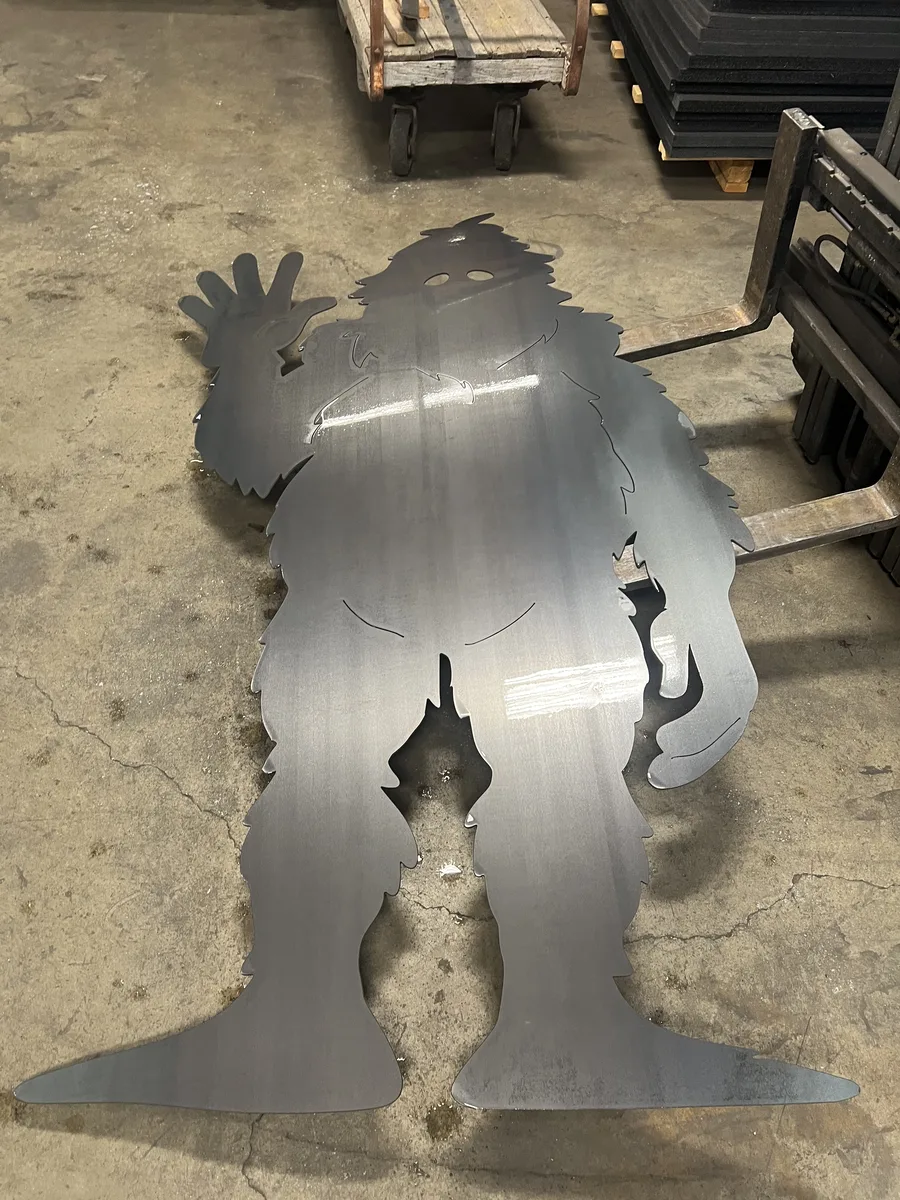 Custom waterjet-cut brushed-steel Bigfoot silhouette with detailed fur edges