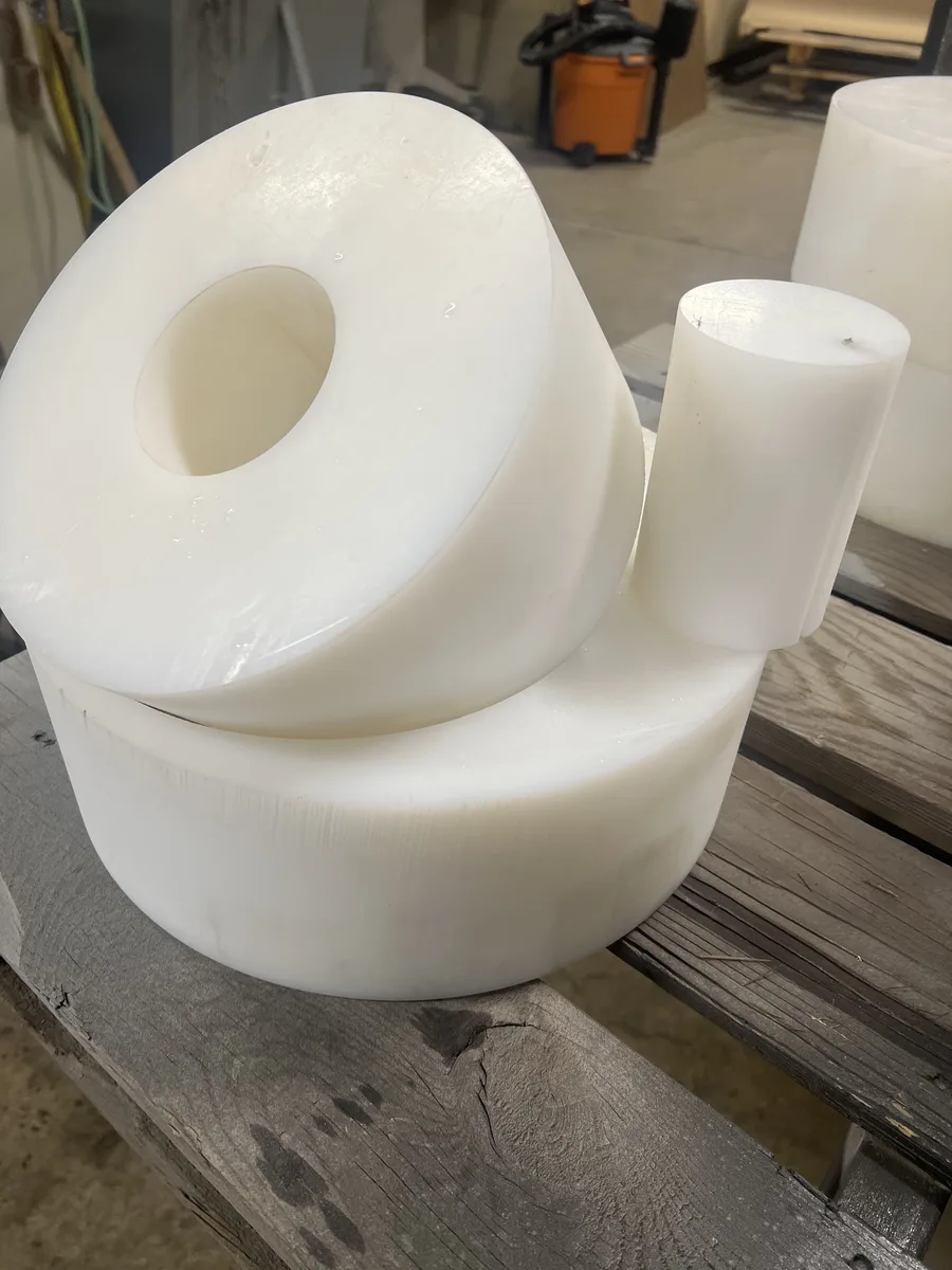 Precision-cut white HDPE plastic components, showing non-metal waterjet capabilities